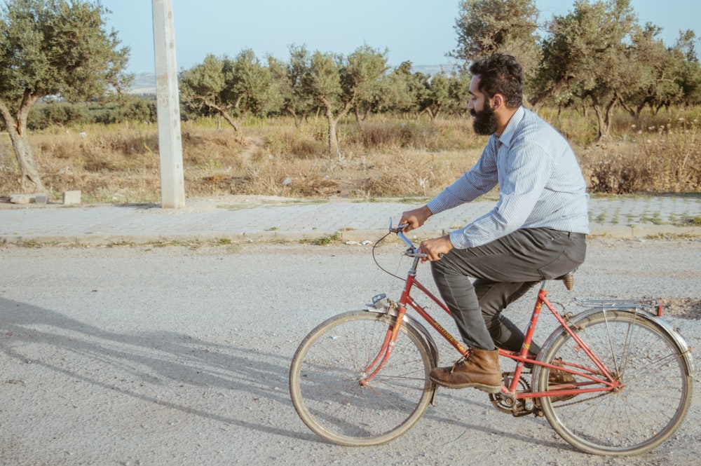 a man riding a red bike down a street