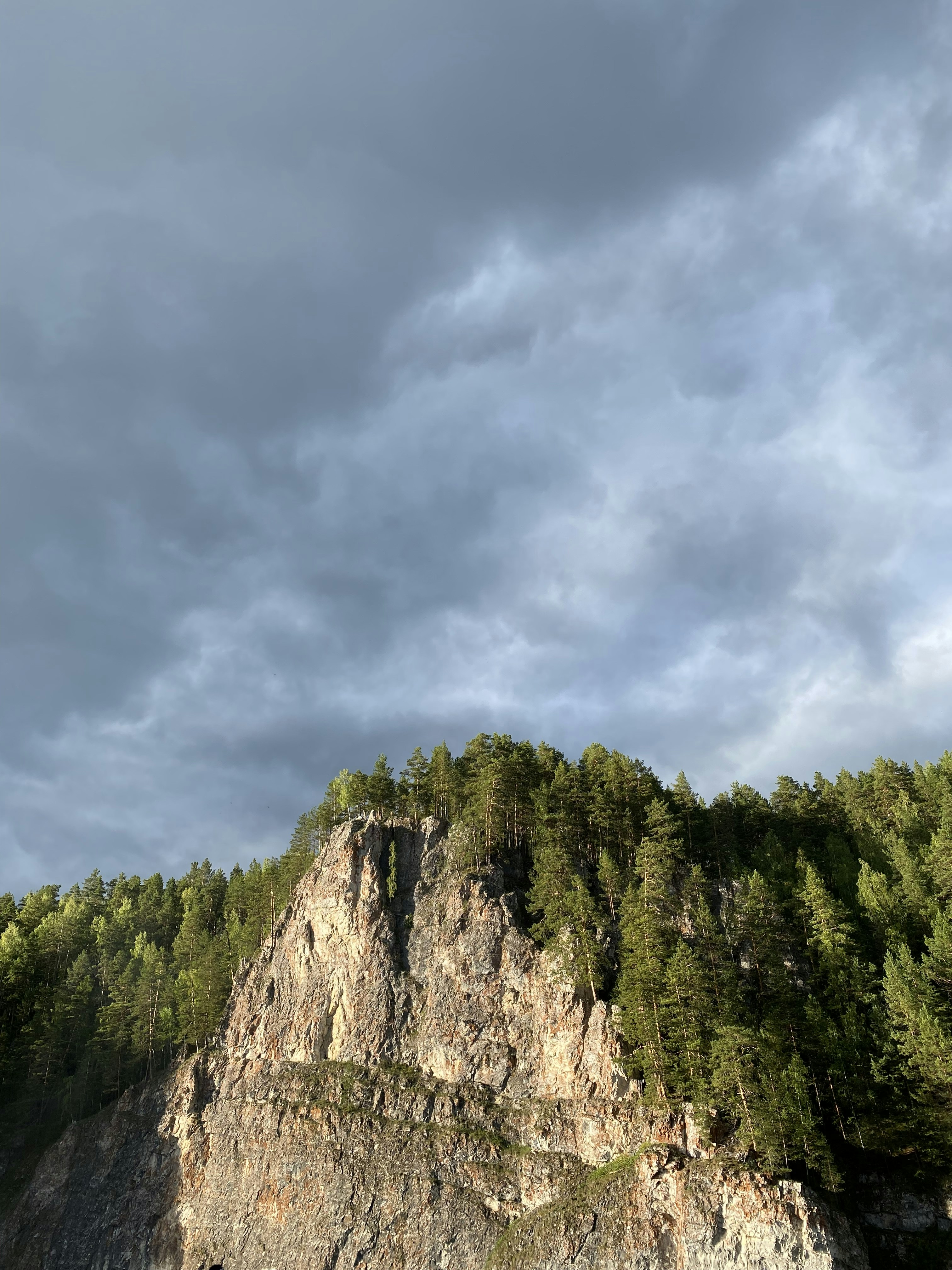 a boat is on the water in front of a mountain