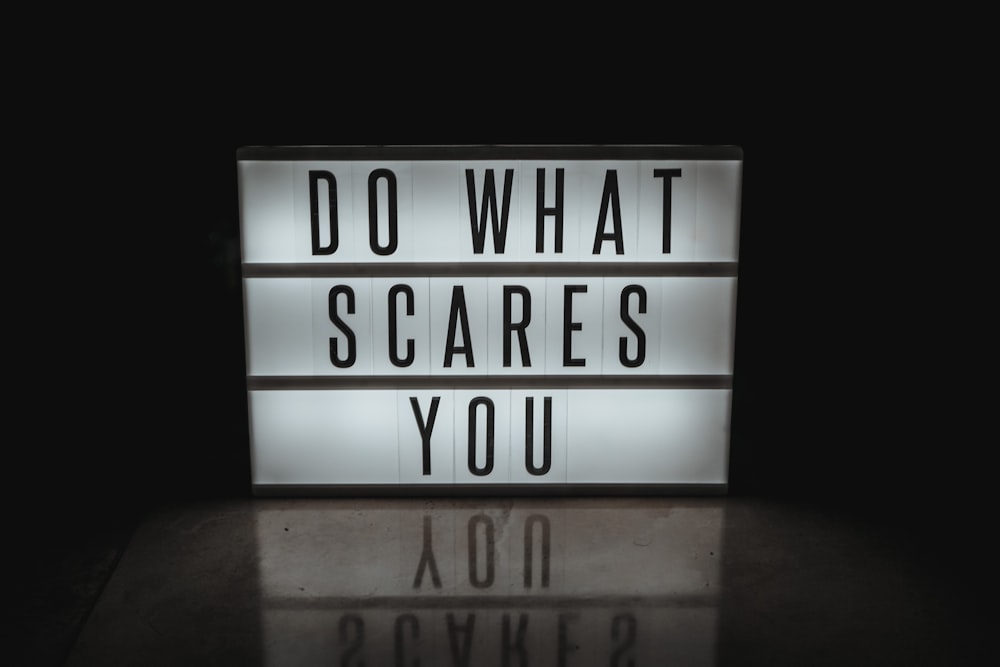 a lighted sign that says do what scared you