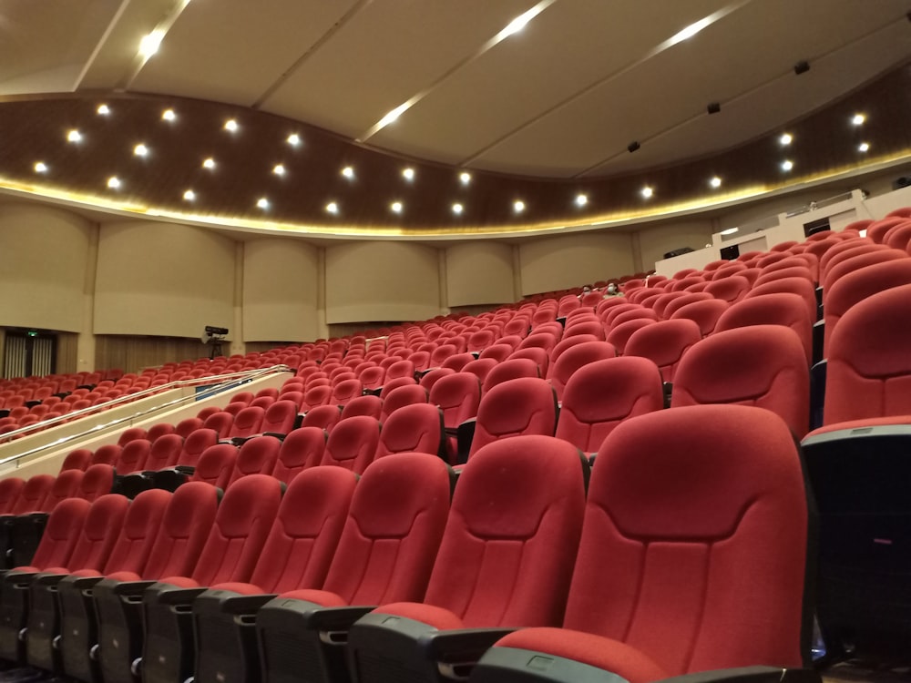 a large auditorium with rows of red seats