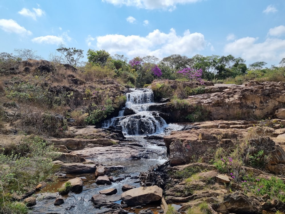 a small waterfall in the middle of a rocky area