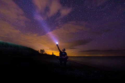 a man holding a flashlight up in the air