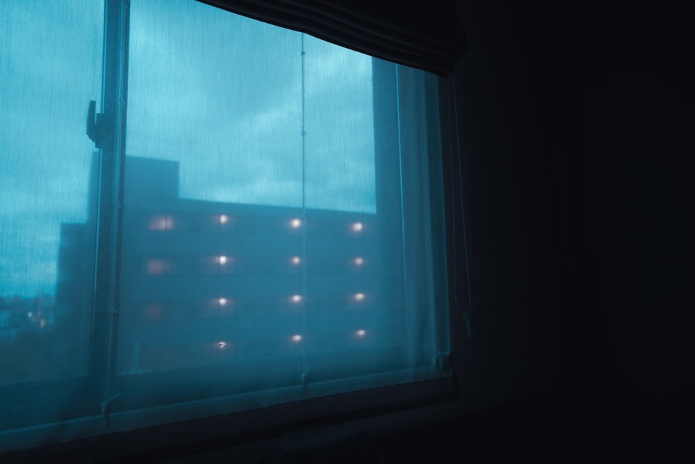 a building is seen through a window in the dark