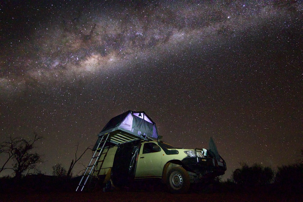 a truck parked under a night sky filled with stars