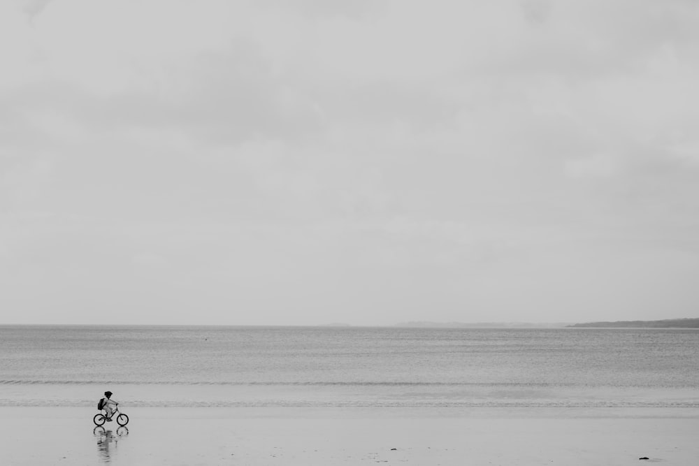 a person riding a bike on a beach
