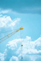 A cheerful crane lifting materials against a clear blue sky with vivid yellow accents.