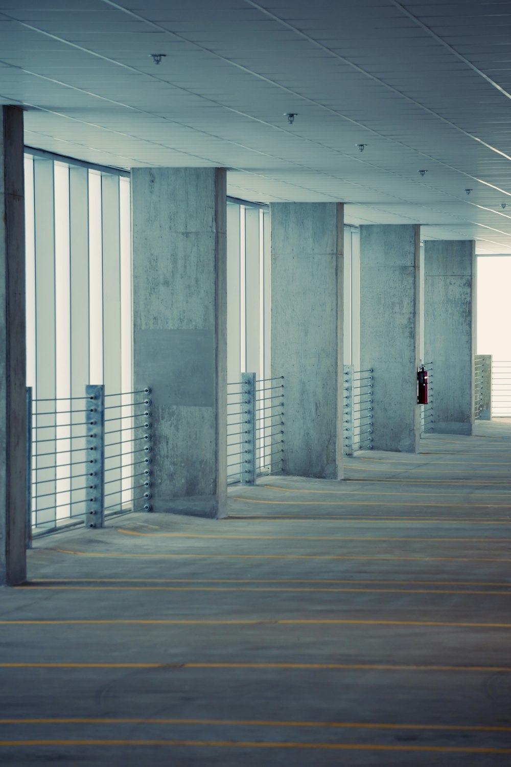 a person standing in an empty room with large windows