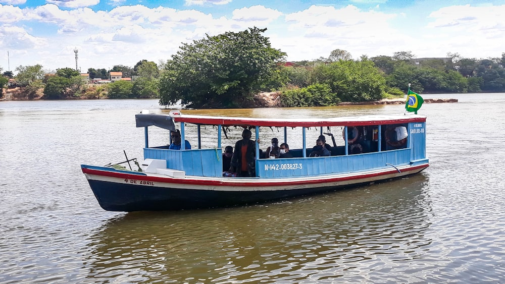 a blue and red boat traveling down a river