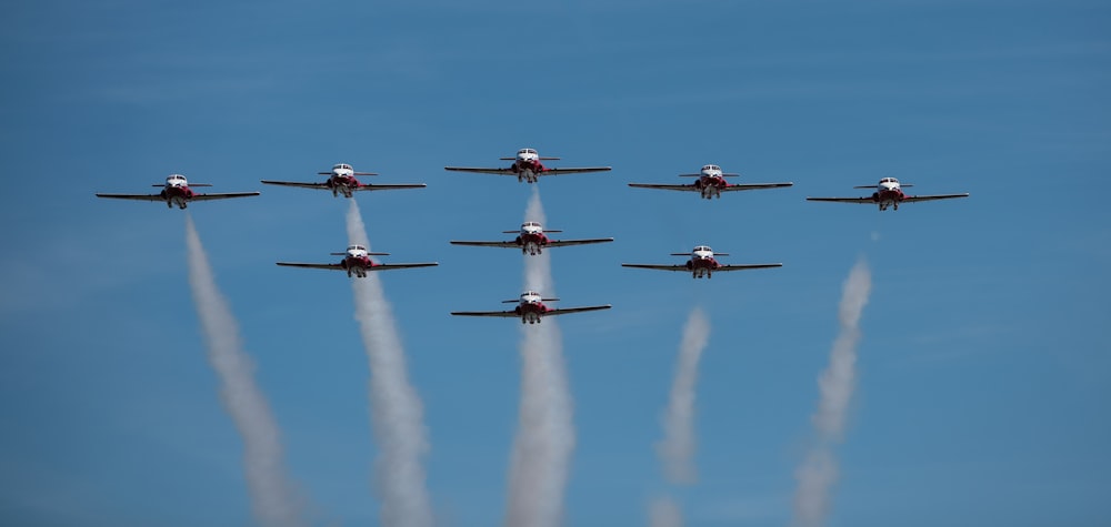 a group of airplanes flying through a blue sky