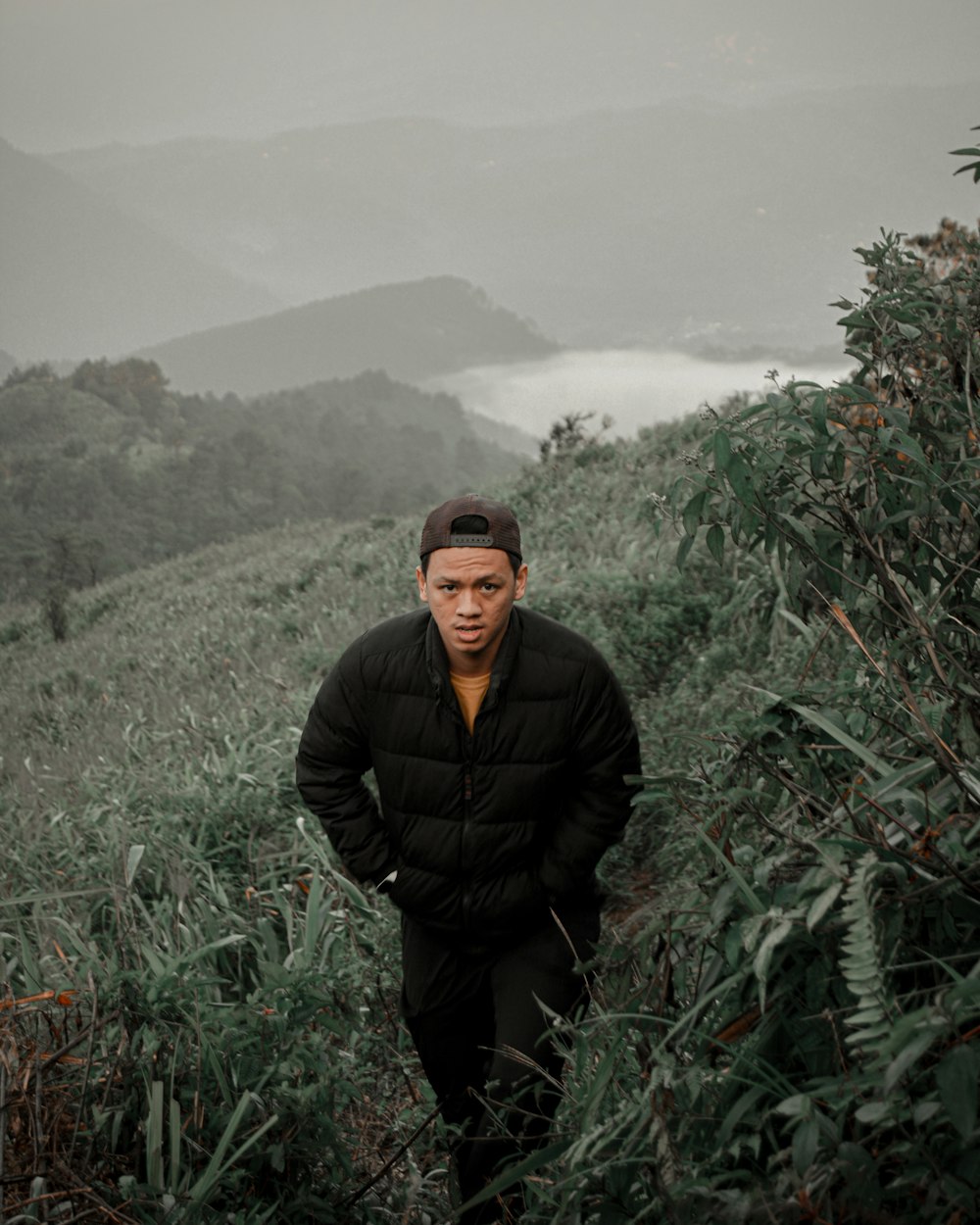 a man in a black jacket standing in a field