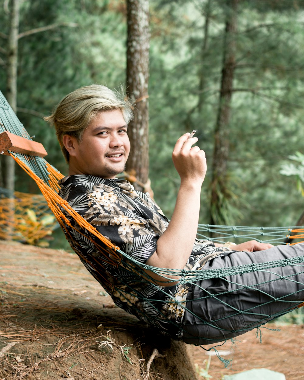 a man sitting in a hammock in the woods
