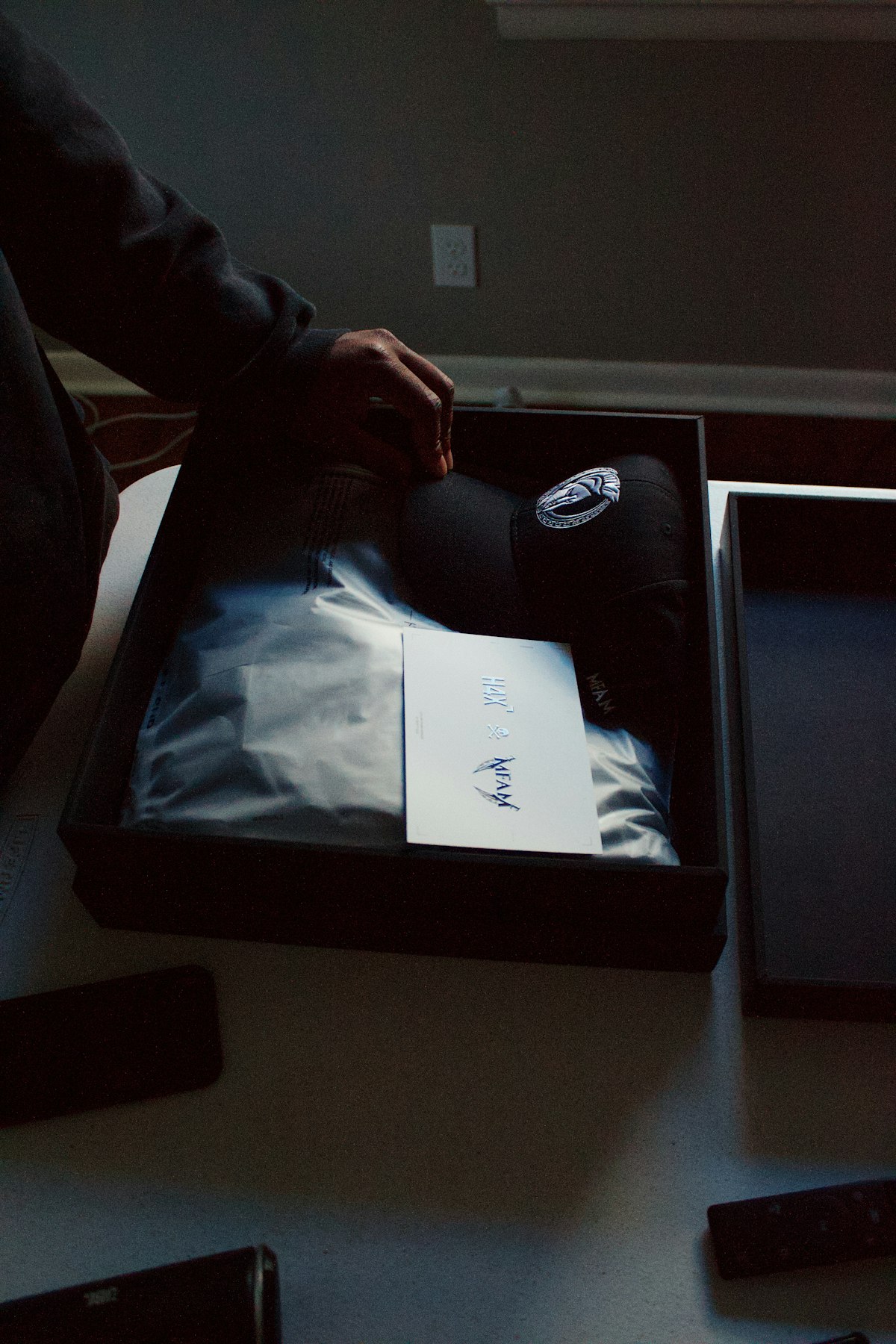A customer opens a delivered cardboard package at home.