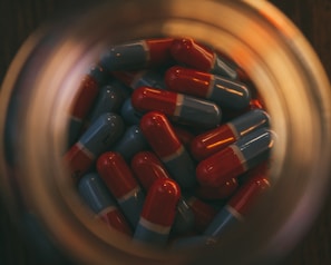 a glass jar filled with red and blue pills