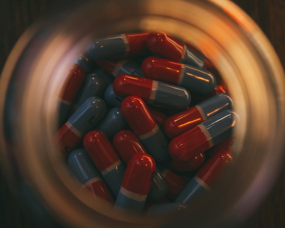 un bocal en verre rempli de pilules rouges et bleues