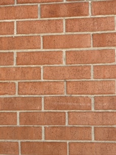 A restored brick wall showing clean, even mortar lines and fresh bricks.