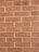 A pattern of uniformly arranged red bricks with beige mortar in between. Each brick has a slightly rough texture, and the wall is well-maintained without any noticeable cracks or damage.