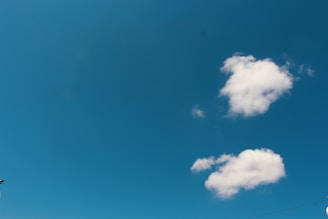 A serene blue sky with soft white clouds, symbolizing hope and healing.