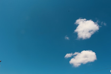 A clear blue sky with a few scattered fluffy white clouds, conveying a sense of openness and calm.