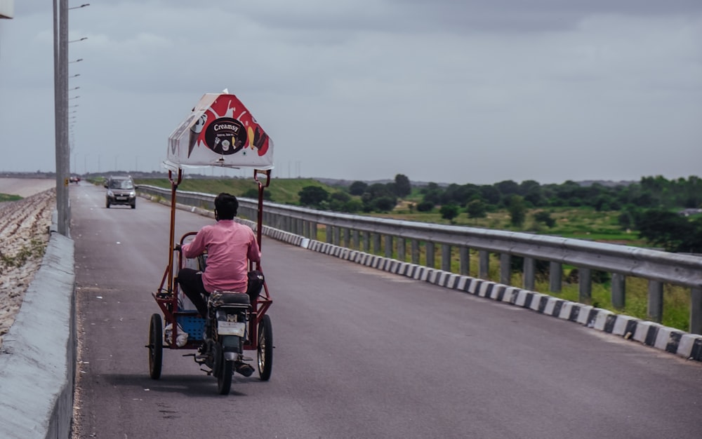 a man riding a tricycle down a road