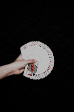 a hand holding a deck of playing cards