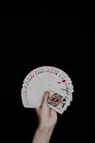 a hand holding a deck of playing cards