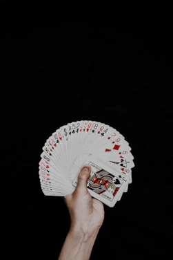 A close-up of a hand holding a deck of playing cards fanned out neatly.