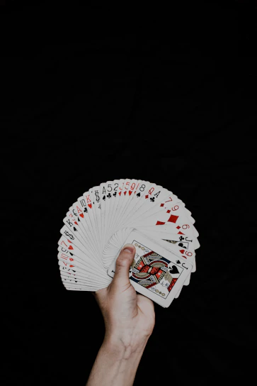 A close-up of a hand holding a deck of playing cards fanned out neatly.