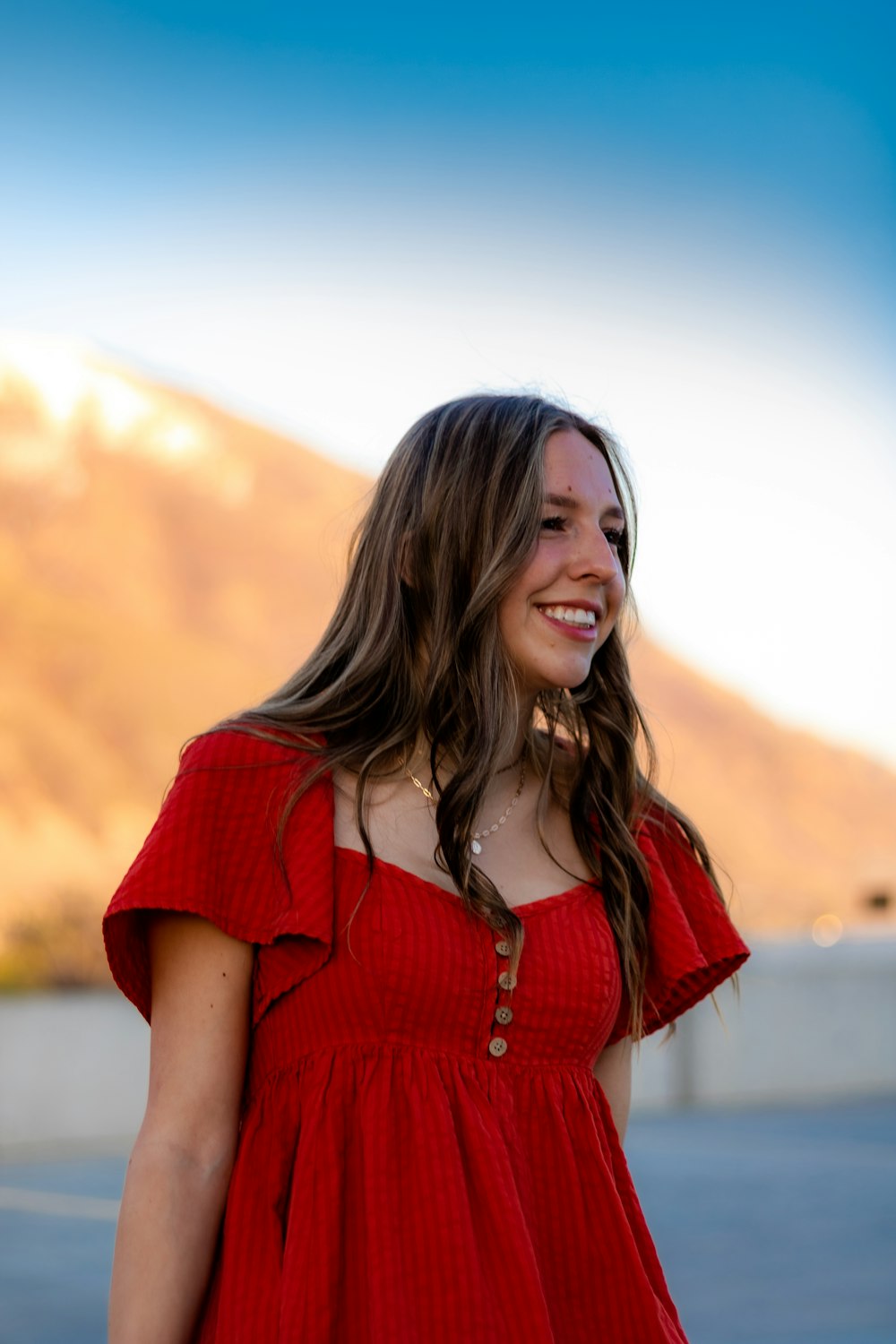 a woman in a red dress smiles at the camera