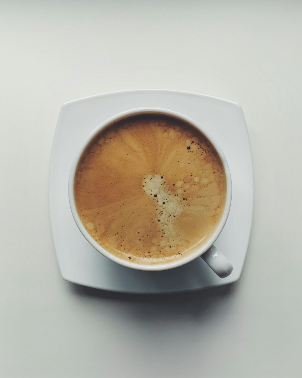 a cup of coffee on a saucer on a table