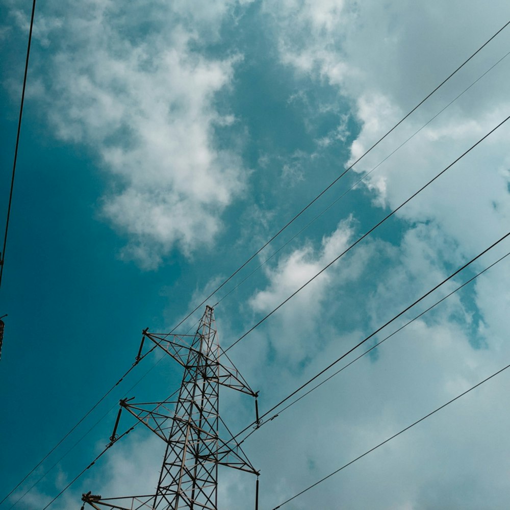 a high voltage power line under a cloudy blue sky