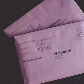 two pink envelopes sitting on top of a table