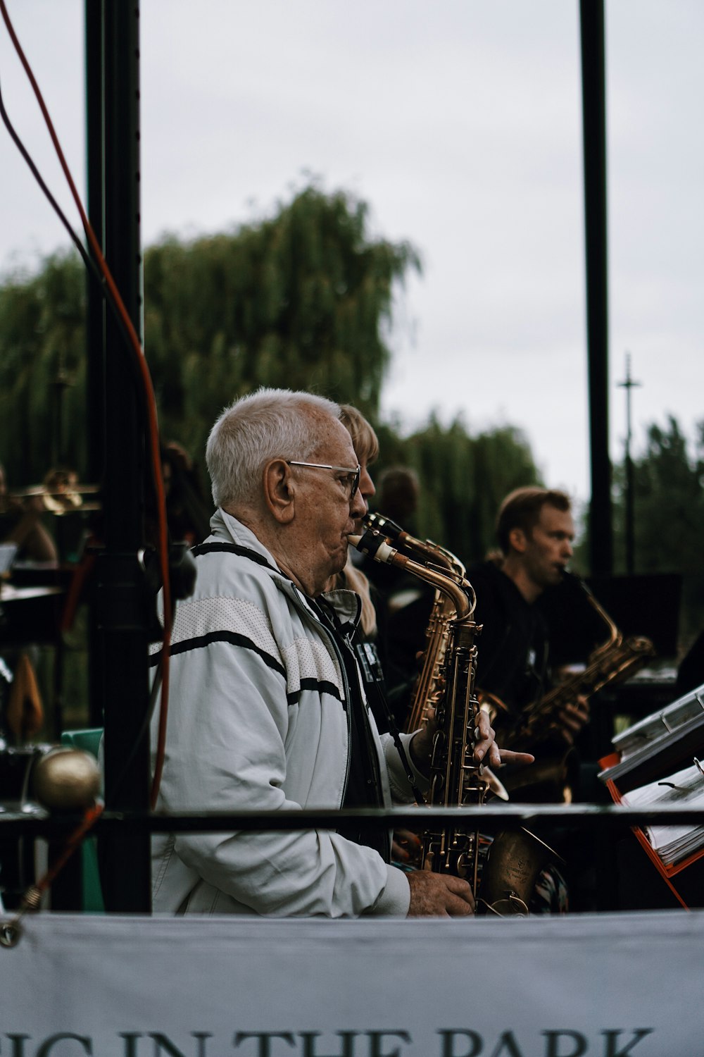 a man playing a saxophone in front of a band