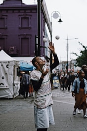 a man juggling a ball on a city street