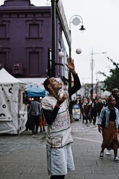 a man juggling a ball on a city street
