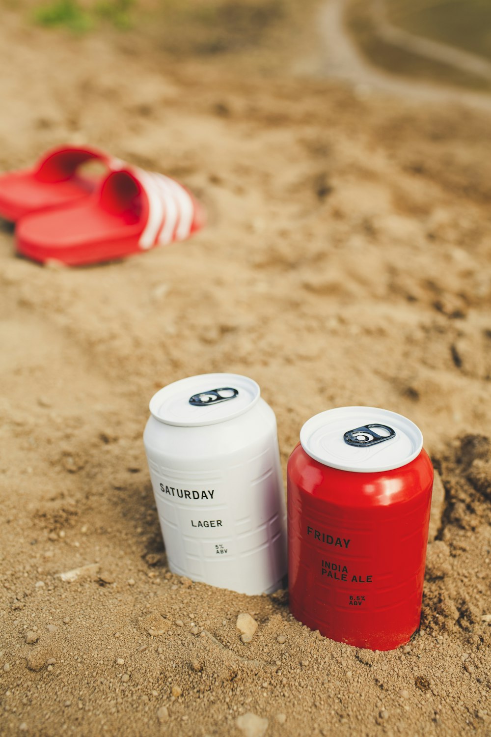 a couple of red and white containers sitting on top of a sandy beach