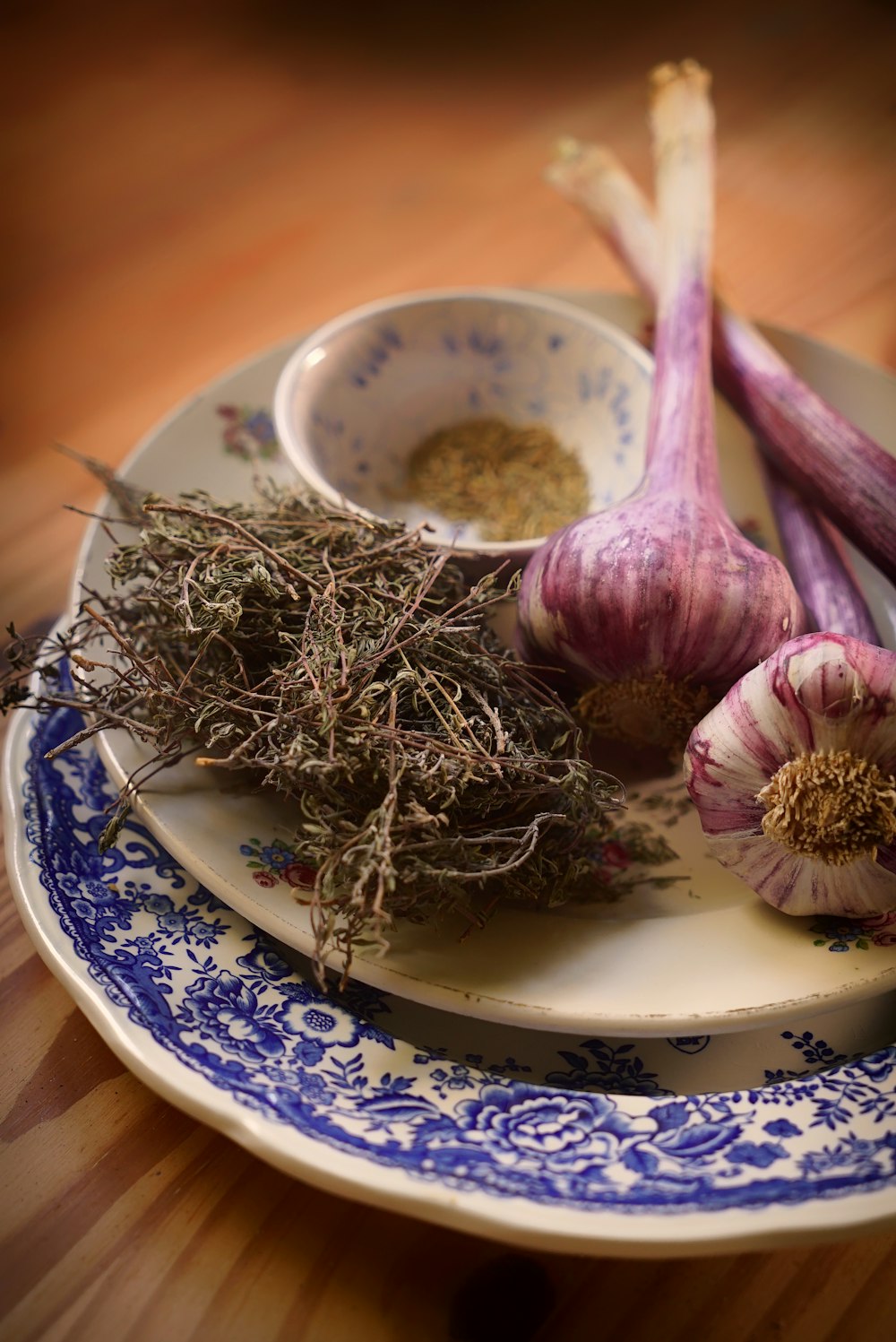 a plate topped with garlic and herbs on top of a wooden table