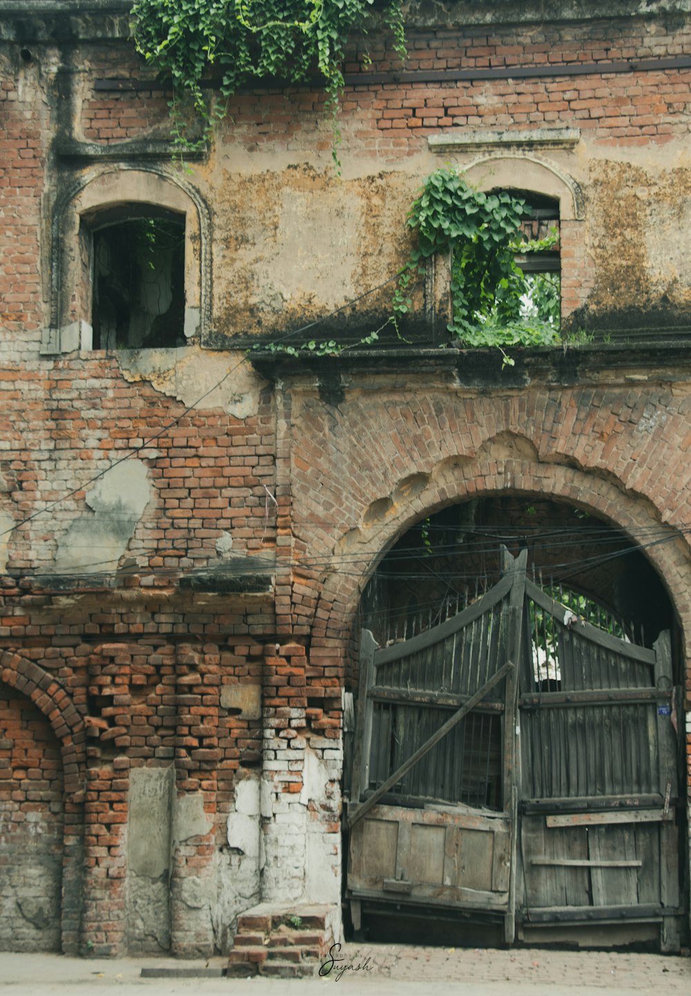 an old brick building with a wooden gate