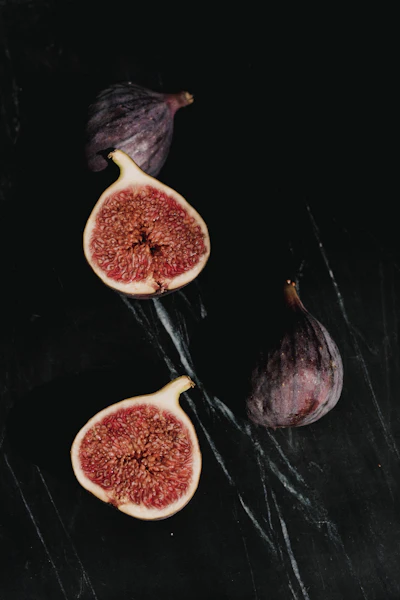 Halved black figs on a dark slate