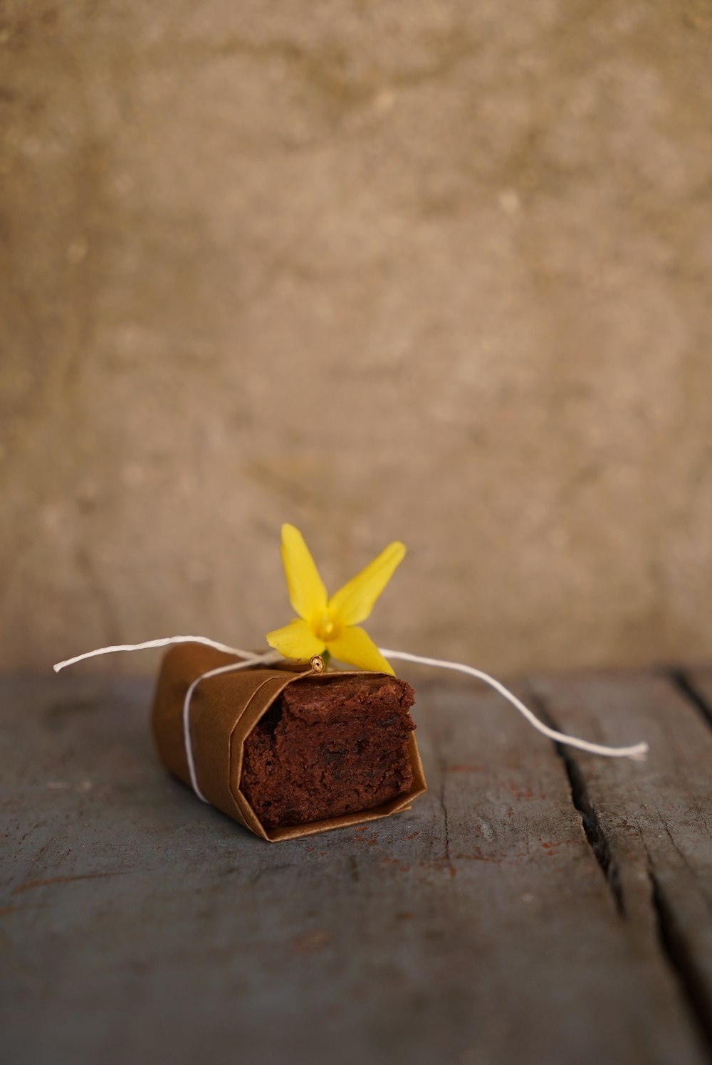 a piece of cake with a yellow flower tied to it