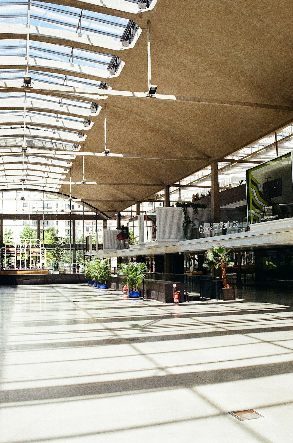 a large open building with a skylight and plants