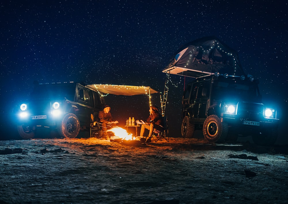 a couple of people sitting around a campfire