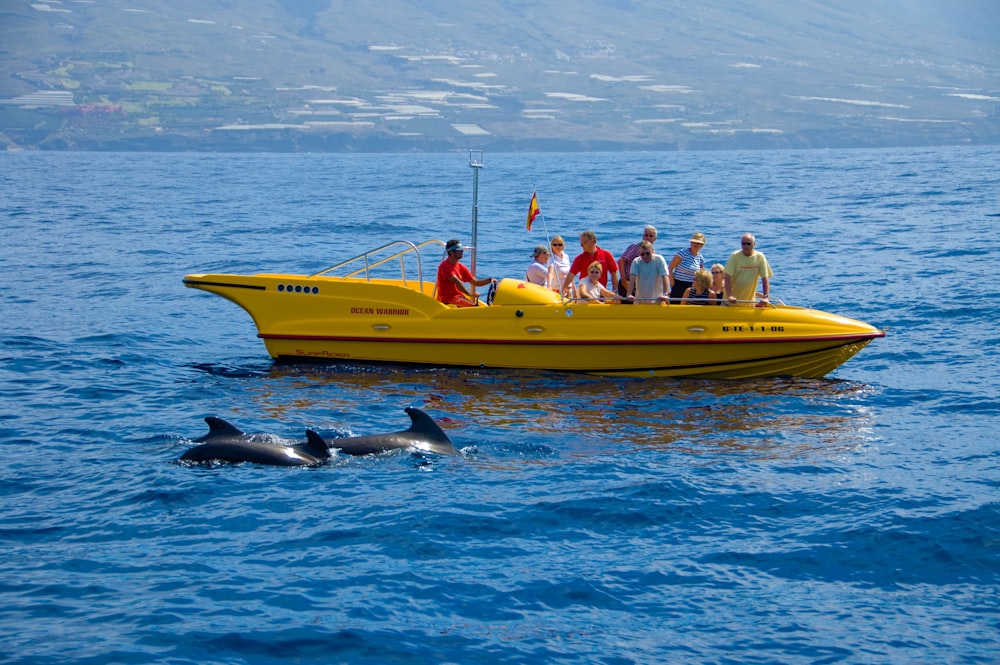 a group of people riding on the back of a yellow boat