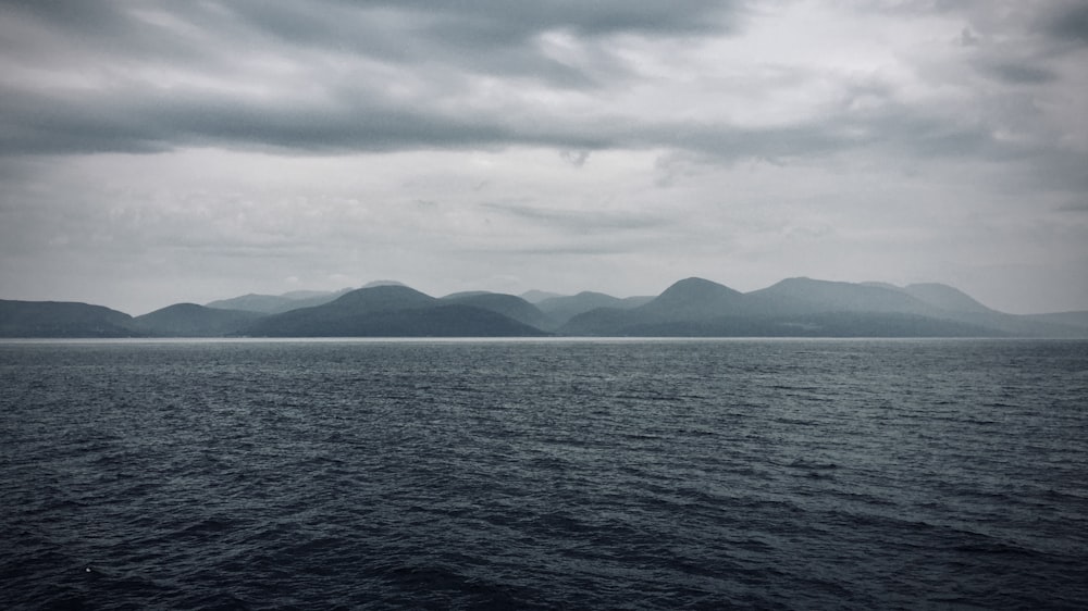 a large body of water with mountains in the background