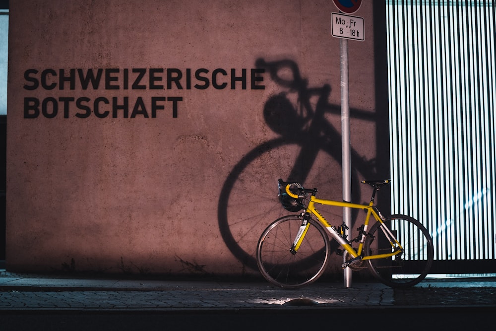 a yellow bike parked next to a building