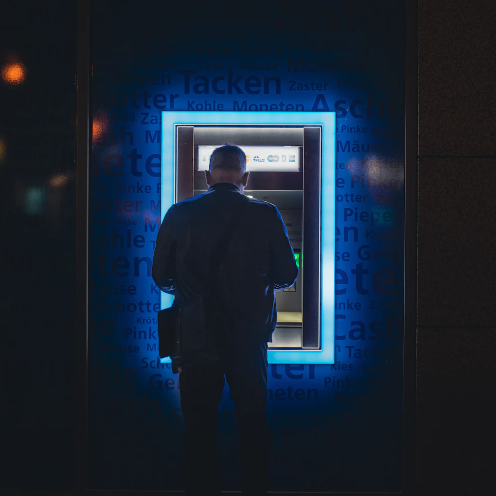 Мужчина у банкомата снимает наличные — ATM на улице