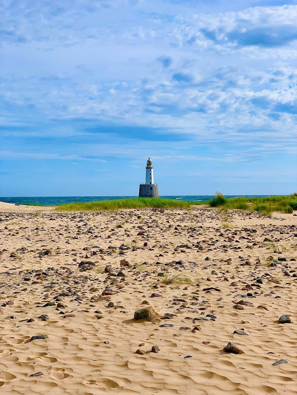 a light house sitting on top of a sandy beach