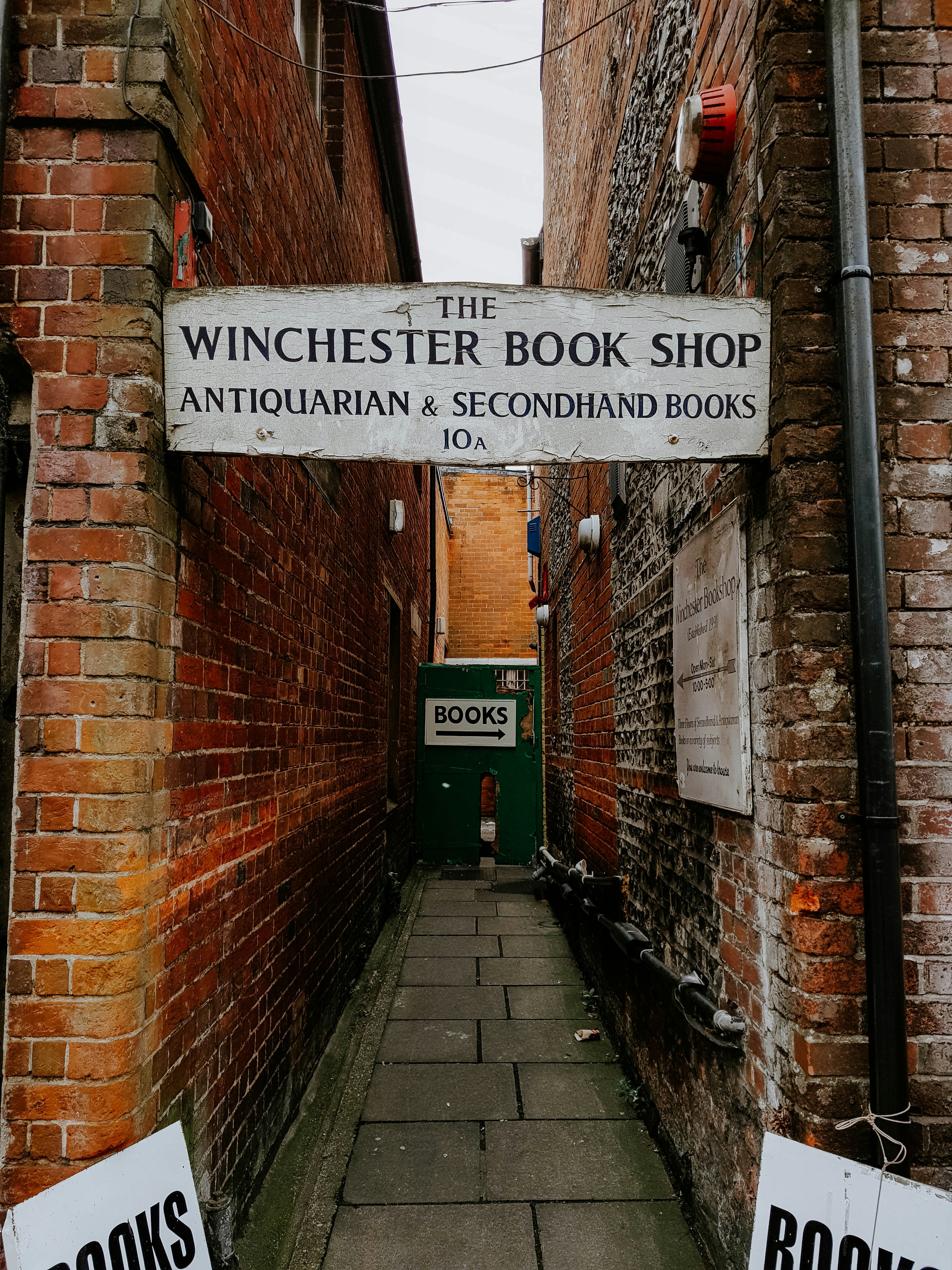 Une ruelle étroite avec un panneau pour la librairie Winchester