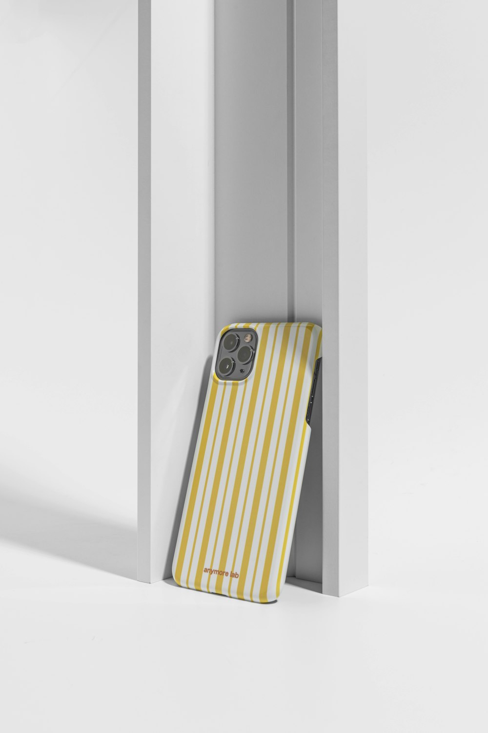 a yellow and white striped phone case in a doorway