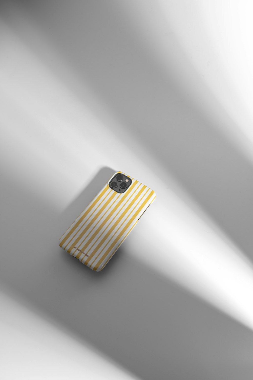 a cell phone with a yellow and white striped case