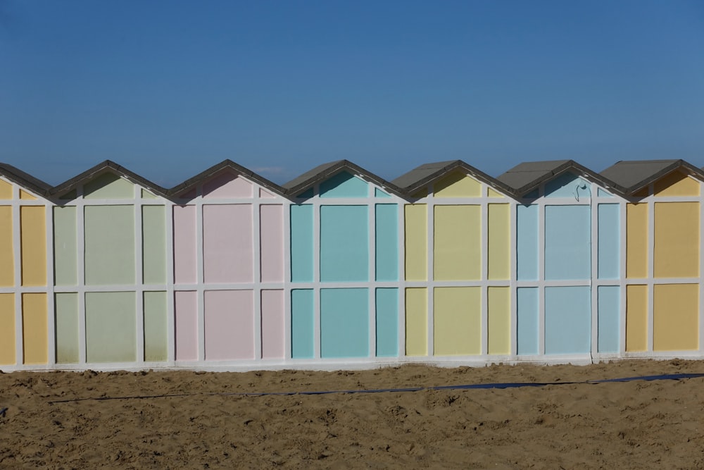 eine Reihe von Strandhütten auf einem Sandstrand